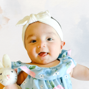 Image of Stellar Digital Marketing's Chief Cuteness Officer. A cute little baby holding a bunny and wearing a white headband.